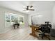 Bright home office with a large bay window, ceiling fan, and light wood-look flooring at 11301 Donneymoor Dr, Riverview, FL 33569