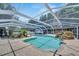 In-ground pool featuring a rock waterfall, and screened enclosure, offering a private oasis at 11301 Donneymoor Dr, Riverview, FL 33569
