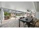 Covered patio with outdoor seating overlooking a screened-in pool and lush landscaping and unique water feature at 11301 Donneymoor Dr, Riverview, FL 33569