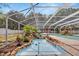 Tranquil screened pool area with custom rock waterfall and spa feature, perfect for relaxation and outdoor enjoyment at 11301 Donneymoor Dr, Riverview, FL 33569