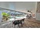 Covered patio with outdoor seating overlooks a screened-in pool, lush landscaping and a unique water feature at 11301 Donneymoor Dr, Riverview, FL 33569