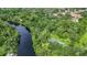 Aerial showcasing community amenities including a river, walking paths, and a tennis court at 11503 Robles Del Rio Pl, Temple Terrace, FL 33617