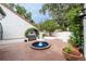 Charming brick courtyard with a fountain, bench seating, and beautiful landscaping for peaceful relaxation at 11503 Robles Del Rio Pl, Temple Terrace, FL 33617