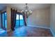 Elegant dining room featuring a decorative chandelier, tile flooring, and a large window with beautiful draperies at 11503 Robles Del Rio Pl, Temple Terrace, FL 33617