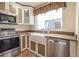 Bright kitchen featuring stainless steel appliances and a farmhouse sink with plenty of natural light at 11503 Robles Del Rio Pl, Temple Terrace, FL 33617