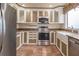 Well-equipped kitchen with stainless steel appliances, white cabinets, and stone countertops at 11503 Robles Del Rio Pl, Temple Terrace, FL 33617