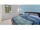 Comfortable bedroom featuring a lamp and a large window for natural light at 12336 Villager Ct, Tampa, FL 33625