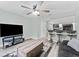 Open-concept living room featuring a modern entertainment center, sofa, and connecting kitchen at 12336 Villager Ct, Tampa, FL 33625
