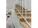 Carpeted staircase with white railings, leading to an open-concept kitchen and living area at 12336 Villager Ct, Tampa, FL 33625