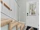 Staircase featuring carpeted steps, white railing, and a view of the front door and landing at 12336 Villager Ct, Tampa, FL 33625