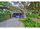 Backyard shed with shaded area, mature trees, and garden landscaping at 1708 Pond Lake Dr, Tampa, FL 33612