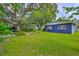 Expansive backyard with lush green lawn, trees, shed, and garden landscaping at 1708 Pond Lake Dr, Tampa, FL 33612