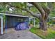 Backyard shed featuring covered storage, mature trees, and garden landscaping at 1708 Pond Lake Dr, Tampa, FL 33612