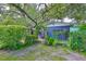 Inviting backyard featuring a lush garden archway leading to a charming blue shed with a covered porch at 1708 Pond Lake Dr, Tampa, FL 33612