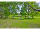 Serene backyard featuring a lake view, mature trees, and lush greenery at 1708 Pond Lake Dr, Tampa, FL 33612