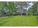 Expansive backyard featuring lush green grass and mature trees providing ample shade at 1708 Pond Lake Dr, Tampa, FL 33612