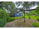 Landscaped backyard with mature trees, a stone patio, and a bench, offering a serene outdoor living space at 1708 Pond Lake Dr, Tampa, FL 33612