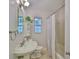 Charming bathroom with a classic pedestal sink, tiled shower, and natural light from a window at 1708 Pond Lake Dr, Tampa, FL 33612