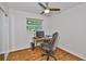 Bedroom with wood floors, ceiling fan, and large window overlooking the yard at 1708 Pond Lake Dr, Tampa, FL 33612