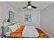 Well-lit bedroom featuring wood floors, a comfortable bed with plush pillows, and a sleek ceiling fan at 1708 Pond Lake Dr, Tampa, FL 33612