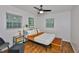 Cozy bedroom with warm wood floors, a modern bed frame, and natural light from two windows at 1708 Pond Lake Dr, Tampa, FL 33612