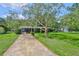Charming single-story home with a well-manicured front lawn and long driveway at 1708 Pond Lake Dr, Tampa, FL 33612
