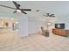 Open living room with tile floors, dual ceiling fans, and a cozy reading nook featuring a recliner and accent table at 1708 Pond Lake Dr, Tampa, FL 33612