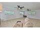 Bright living room with tile floors, two ceiling fans, and natural light from multiple windows at 1708 Pond Lake Dr, Tampa, FL 33612