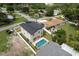 An aerial view of a backyard with a pool, lush landscaping, and a privacy fence at 1808 W Erna Dr, Tampa, FL 33603
