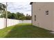 Backyard featuring a well-kept lawn, bordered by a white privacy fence, with a young palm tree at 1808 W Erna Dr, Tampa, FL 33603