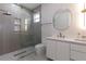 Modern bathroom featuring glass shower with designer tile, floating vanity, and round mirror at 1808 W Erna Dr, Tampa, FL 33603