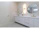 Bathroom with double sink vanity, modern lighting, decorative mirrors and stylish wallpaper at 1808 W Erna Dr, Tampa, FL 33603