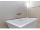 Modern white bathtub is accented by stylish tile and brushed gold fixtures for a luxurious spa feel at 1808 W Erna Dr, Tampa, FL 33603