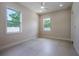 Bright bedroom with tile floors, ceiling fan, and two windows offering natural light at 1808 W Erna Dr, Tampa, FL 33603