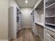 Walk-in closet features white shelving with drawers and hardwood floors at 1808 W Erna Dr, Tampa, FL 33603