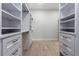 Walk-in closet with white custom built-in shelves, drawers and bronze hardware at 1808 W Erna Dr, Tampa, FL 33603