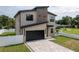 Stylish two-story house with a modern design, featuring a paver driveway and black framed windows at 1808 W Erna Dr, Tampa, FL 33603
