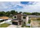 Contemporary home featuring a stylish facade, two-car garage, a paver driveway, and a white fence at 1808 W Erna Dr, Tampa, FL 33603