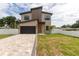 Modern two-story house with paver driveway, sleek black garage door, and minimalist landscaping at 1808 W Erna Dr, Tampa, FL 33603