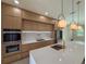 A modern kitchen with wood cabinets, white countertops, stainless steel appliances, and pendant lighting at 1808 W Erna Dr, Tampa, FL 33603