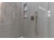 Shower featuring beige tile surround, built-in shelving, and brushed gold hardware at 1808 W Erna Dr, Tampa, FL 33603