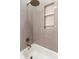 Close-up of shower with gold fixtures and tile with a built-in shelf at 1808 W Erna Dr, Tampa, FL 33603
