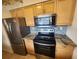 Kitchen with stainless steel appliances, granite countertops, and natural wood cabinets at 1975 W Bay Dr # 304, Largo, FL 33770