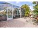 Screened-in patio with dining and lounge seating, brick flooring and view of tropical landscaping at 22623 Cliffside Way, Land O Lakes, FL 34639