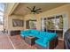 Covered patio featuring stylish blue cushioned seating area with ceiling fan and brick flooring at 22623 Cliffside Way, Land O Lakes, FL 34639