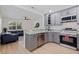 Modern kitchen featuring stainless steel appliances, stylish gray cabinets, and an open view to the living room at 2311 16Th S Ave, St Petersburg, FL 33712