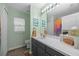 Bright bathroom with modern vanity, marble countertop, and colorful shower curtain at 3725 Grand Forks Dr, Land O Lakes, FL 34639