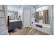 This bright bathroom features a separate shower and tub, dual vanity and wood look floors at 3725 Grand Forks Dr, Land O Lakes, FL 34639