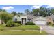 Beautifully landscaped single-story home with a two-car garage and lush green lawn at 3725 Grand Forks Dr, Land O Lakes, FL 34639