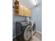 Well-equipped laundry room with modern washer and dryer, plus ample cabinet storage at 3725 Grand Forks Dr, Land O Lakes, FL 34639
